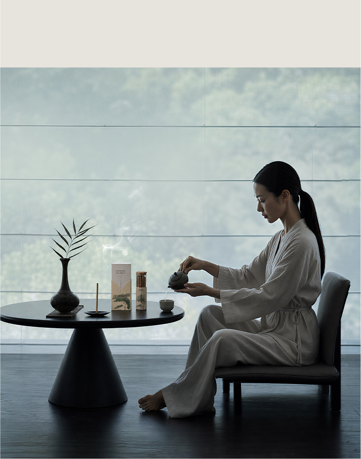 Woman preparing a tea ritual beside incense